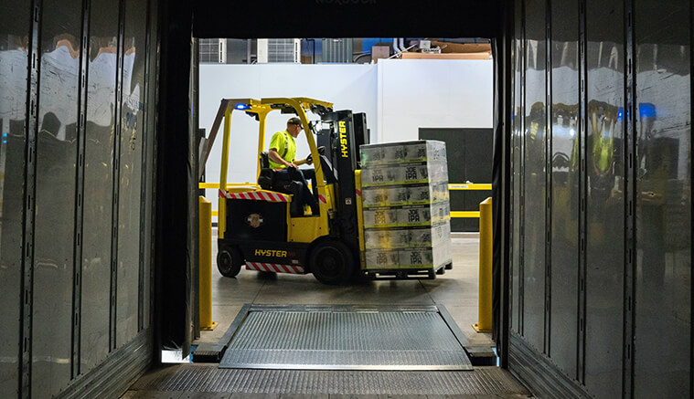 Man driving a forklift in a warehouse moving boxes