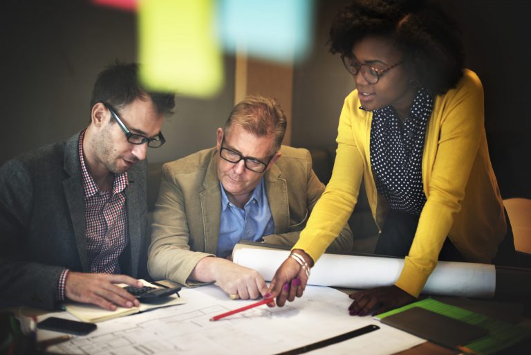 two man and a woman making plans to start a business on table