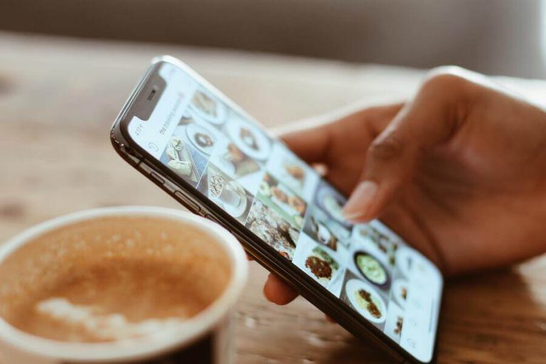 Person scrolling on social media while having a coffee