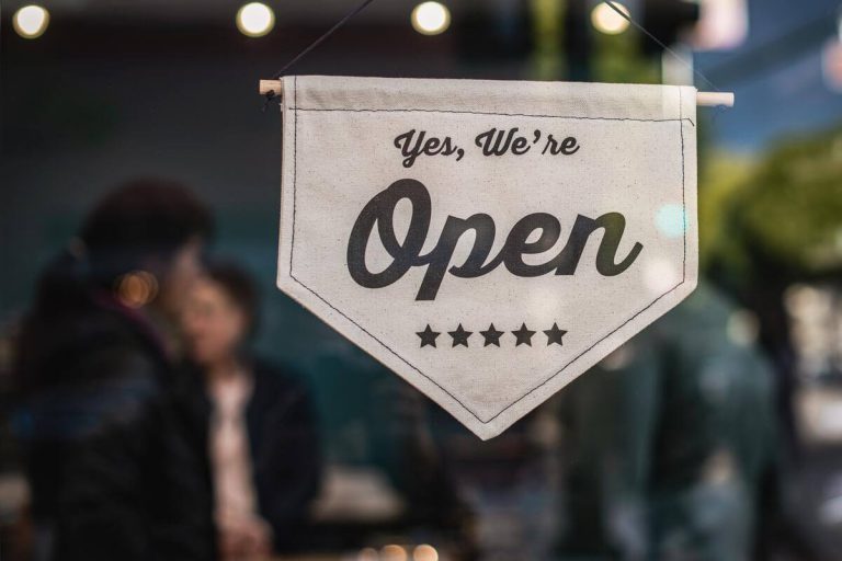 Window sign that says "Yes, we're open."