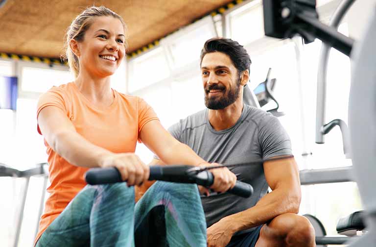 Young woman doing exercises with personal trainer