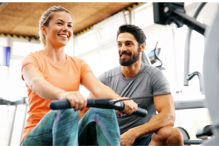 Young woman doing exercises with personal trainer