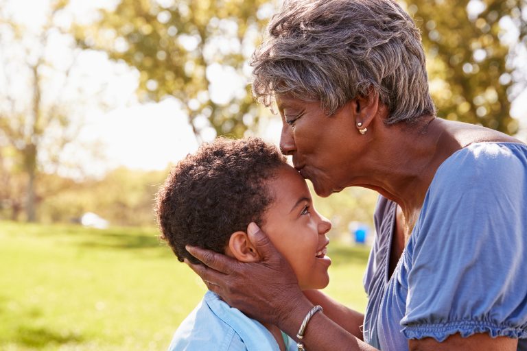 black grandmother kissing grandson on forehead