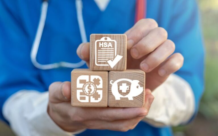Nurse holding wood building blocks for HRA vs HSA vs FSA
