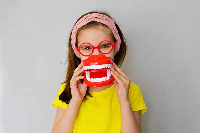 child wearing glasses and tooth model