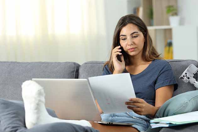 Injured woman on the phone with personal health advocate reviewing medical bill