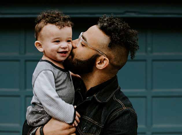 Hispanic father holding little boy