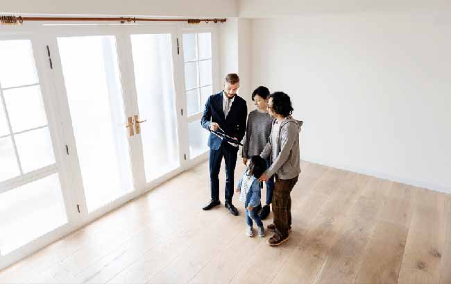 Real estate agent showing Asian family with small young girl a home